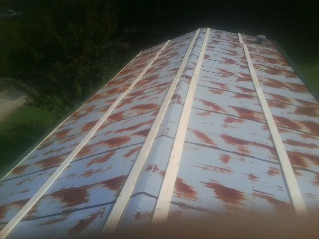 Rusted metal roof panels with new wood purlins before replacement — Storm Damage Roof Repair in Azle by Roofing Brothers