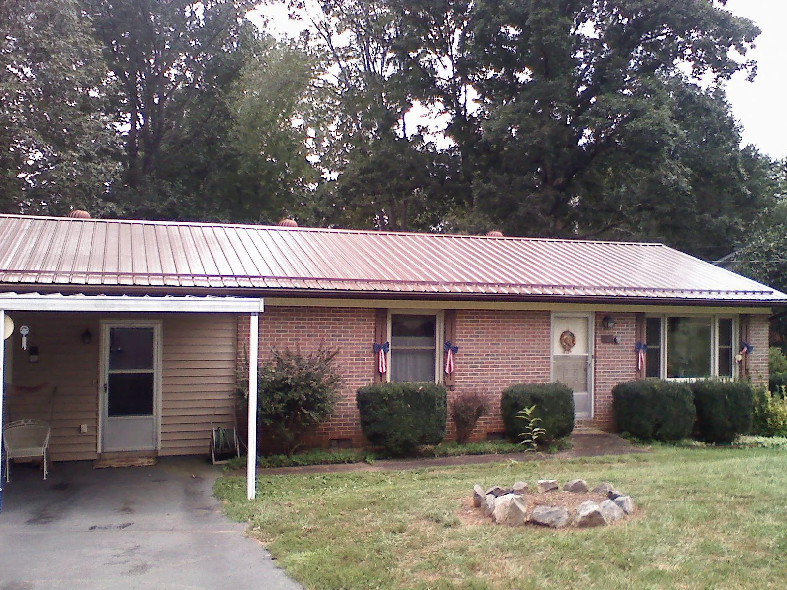 Bronze metal roof and carport on a brick ranch home — Roof Repair work by our crew in Azle