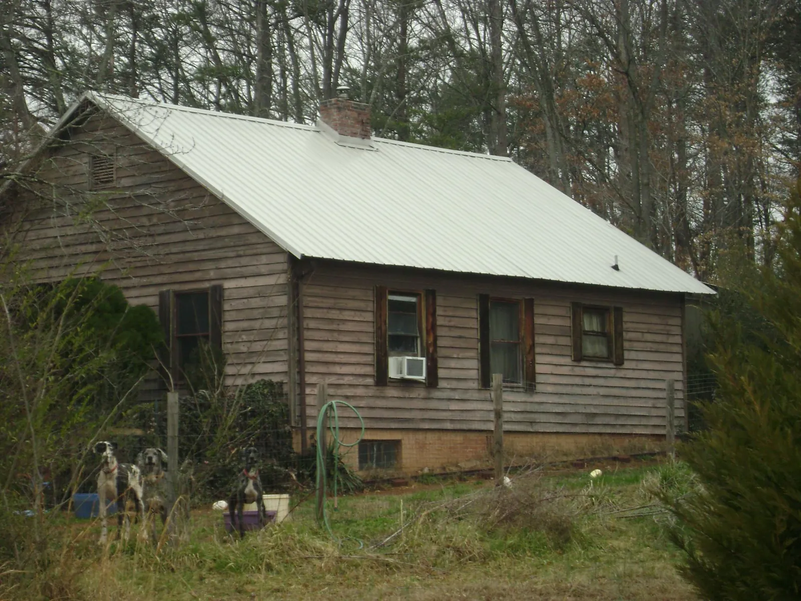 White metal roof on an old wood sided farmhouse, from a Metal Roof Installation job in Azle